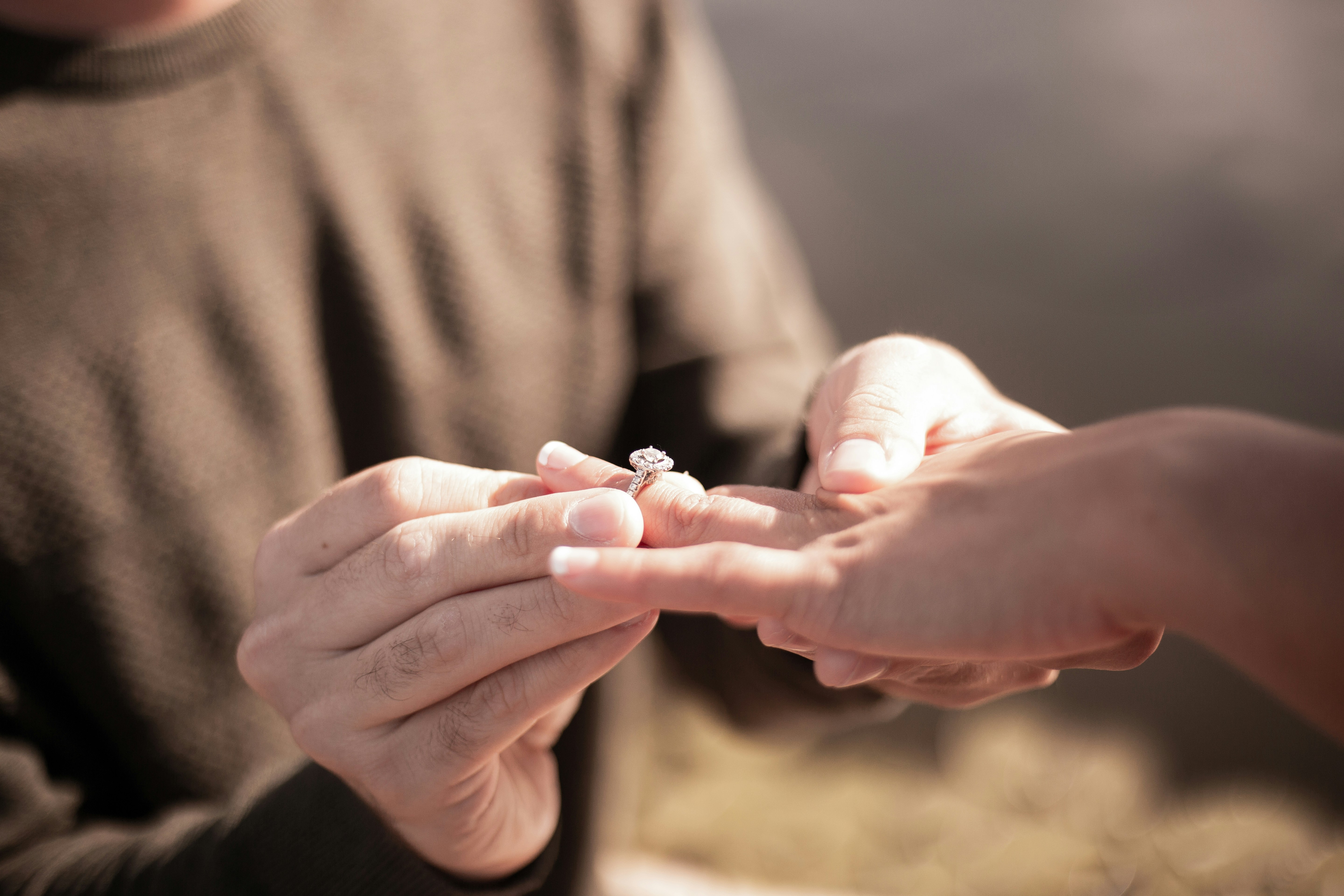 A couple sharing a moment as a ring is placed on a finger